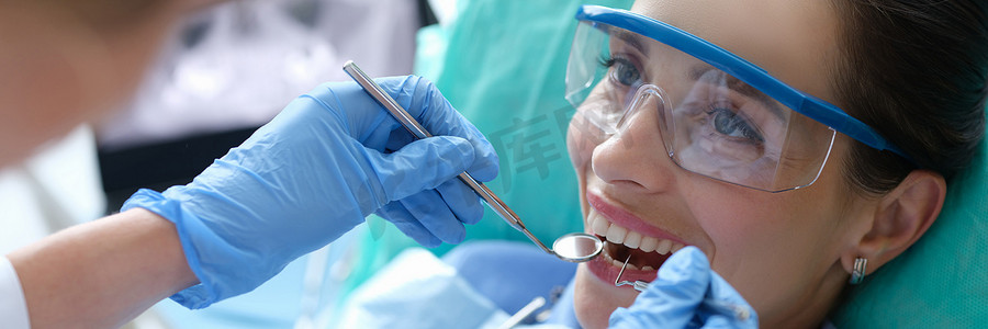 医生在临床上使用牙科器械检查女性患者的口腔