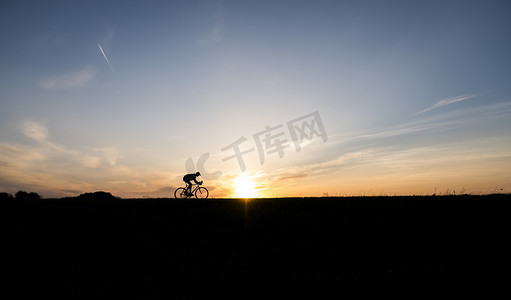 乌克兰卢茨克 — 2018年4月5日：日落时分，男子在田野上骑自行车。