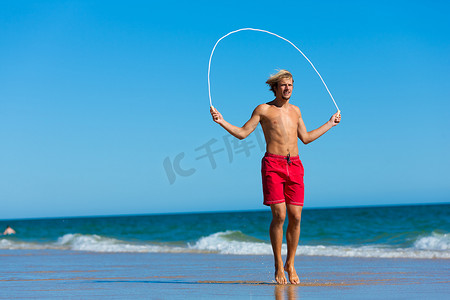 年轻人在沙滩上跳绳