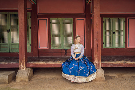 韩服女摄影照片_在韩国宫殿穿着韩服的年轻白人女游客。
