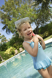 泳池边戴着潜水面罩和通气管的快乐可爱小女孩