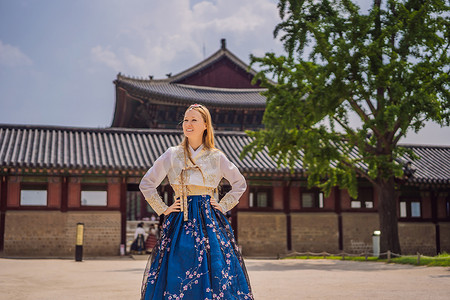 韩服图腾摄影照片_在景福宫穿着韩服的年轻白人女游客。