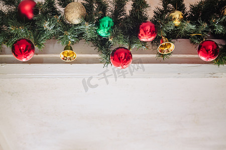 圣诞树上的玻璃球和装饰品。白色背景上有灯和红绿金球的花环