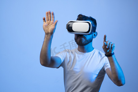 年轻人开发人员在虚拟世界中使用 VR 耳机并创建新产品和应用程序。