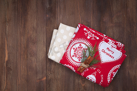 棕色的圣诞背景摄影照片_木制背景上的圣诞厨房毛巾
