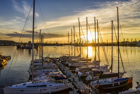 游艇和小船在港口欣赏令人惊叹的日落。