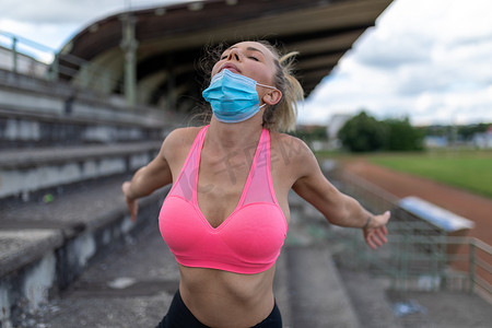 妇女在户外训练或跑步后摘下医用面罩