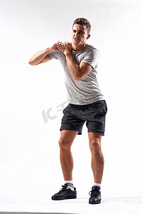 浅色背背摄影照片_穿着短裤和全长 T 恤的运动员在浅色背景下锻炼