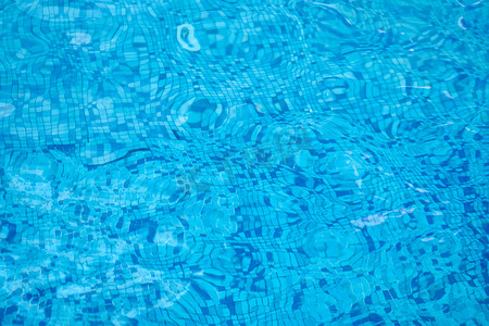 水背景在蓝色游泳池，与太阳反射的水表面