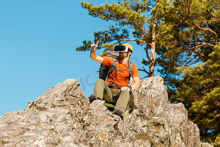 成功的年轻人，使用虚拟现实护目镜在山中游览，夏天度假