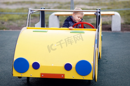 一辆黄色的大玩具车和里面的一个小男孩