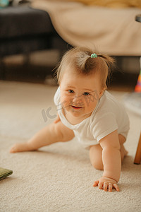 太阳光线摄影照片_一个 7 个月大的女孩站在家里的地毯上，摆出蜘蛛侠的姿势。