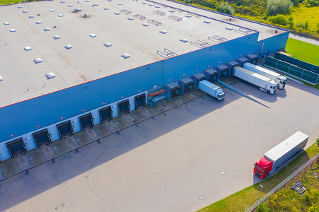 许多卡车正在卸载商品的工业装卸区的空中拍摄。
