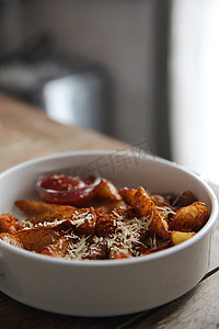 麻辣串串logo摄影照片_木质背景上配有番茄酱的新鲜炸薯条