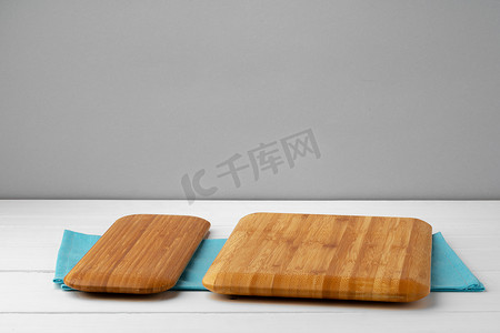 白色木桌上棉餐巾上的木切板