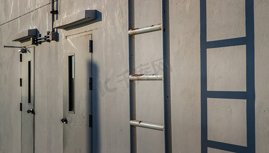 附有白色金属防火梯，两扇门连在墙上，通向建筑物的屋顶。