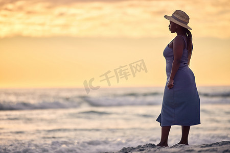 我可以闭着眼睛飞回家……拍摄一个面目全非的女人在日落时沿着海滩行走。