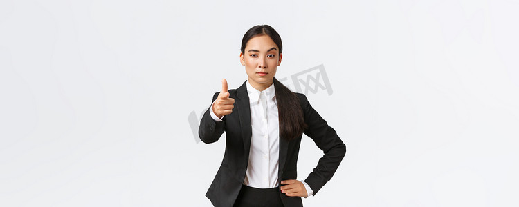 自信严格的办公室经理，亚洲女企业家指着镜头，表情严肃，提出工作机会，下达任务，挑选员工工作，站立白色背景