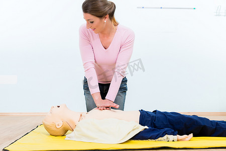 急救措施摄影照片_急救课程中练习心脏按摩的妇女