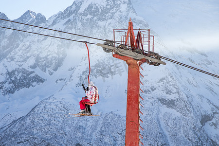 电梯乘坐摄影照片_人们在山上乘坐滑雪缆车
