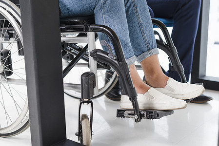 残疾妇女的脚轮椅白色地板