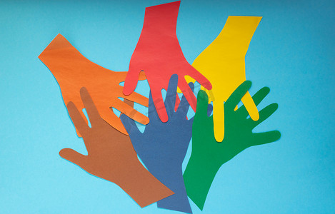 抽象背景在蓝色背景上打开五颜六色的纸手掌。自闭症日和青年团结日的概念