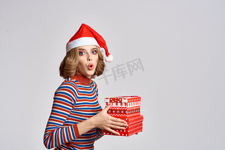 快乐的女人手里拿着圣诞礼物头戴红帽子新年假期的剪影