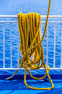 书本打光摄影照片_黄色编织绳挂在船栏杆上