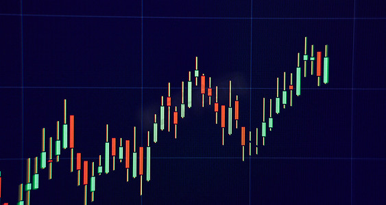 趋势向上摄影照片_技术价格图表和指标，蓝色主题屏幕上的红色和绿色烛台图表，市场波动，上下趋势。
