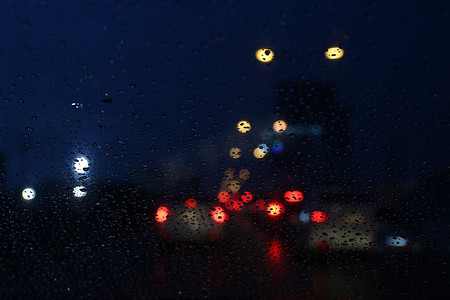 夜生活背景散景和玻璃上的雨滴模糊散景照明彩色凝结