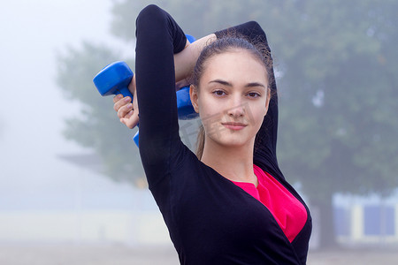 训练期间用哑铃锻炼的年轻健身女孩