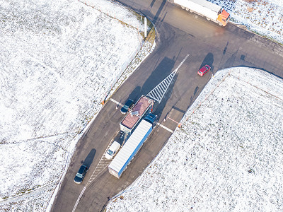 物流园区的鸟瞰图，包括仓库、装卸中心和许多半卡车，货物拖车站在斜坡上装卸货物 a