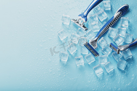 冷淡的蓝色背景上的三台剃须机加冰。