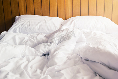 枕头摄影照片_卧室床上的白色枕头和毯子有皱纹凌乱
