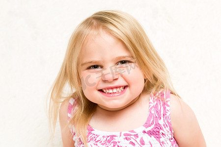 美丽的幼儿女孩厚脸皮地笑着的特写肖像