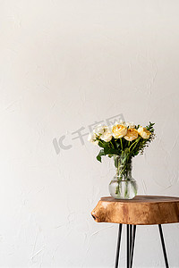 简约的家居内饰，配有时尚的木制咖啡桌和一束新鲜玫瑰