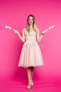 穿着粉红色衣服的漂亮女孩像王子一样在棍子上展示棉花糖。