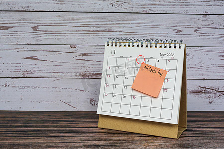 2022 年 11 月的日历在木桌上，日期圈和便利贴上的文字。