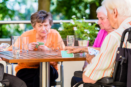 一群老年人在养老院的露台上玩棋盘游戏