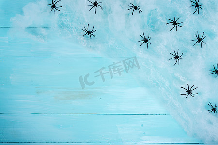 万圣节假期背景，蓝色木质上有蜘蛛和网