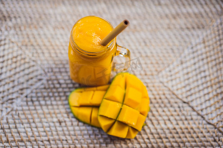 果汁吸管摄影照片_一杯用竹吸管制成的芒果奶昔。