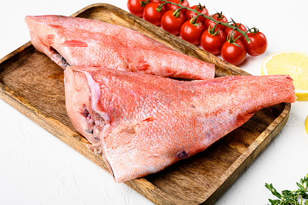 红海鲈鱼或大眼鱼，在木制服务板上，在白色石桌背景中