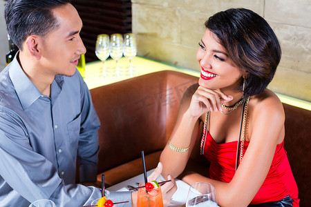 高档眼镜摄影照片_亚洲夫妇在高档酒吧喝鸡尾酒
