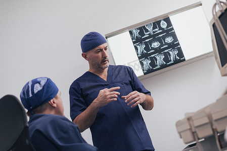 脊椎治疗摄影照片_骨科医生团队在诊所或医院检查数字 X 射线图片