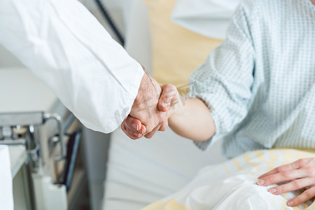 医生在病床上与病人握手