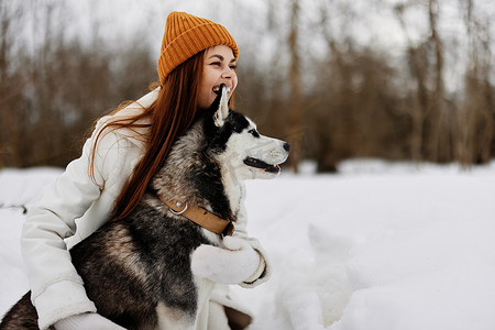 冬日雪地里遛狗的女冬装画像