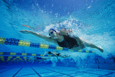 女游泳运动员在泳池水下比赛