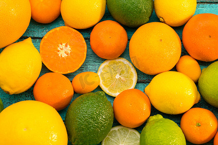 蓝色木桌上各种整体和切片柑橘类水果的顶部视图