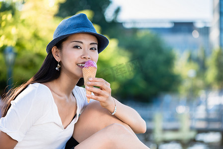 年轻的日本女人在户外吃冰淇淋