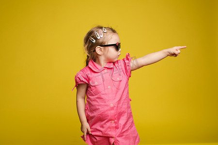 小女孩在裙子和太阳镜指示方向。